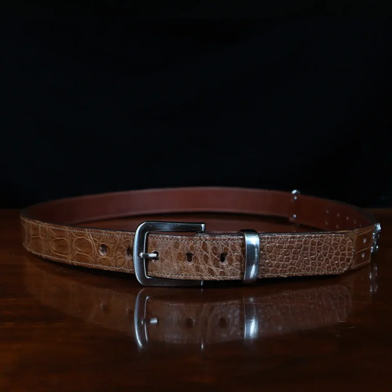 An American Alligator Belt with Nickel hardware showing the front view on a wooden table with black background - id 001