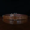 An American Alligator Belt with Nickel hardware showing the back view on a wooden table with black background - id 002