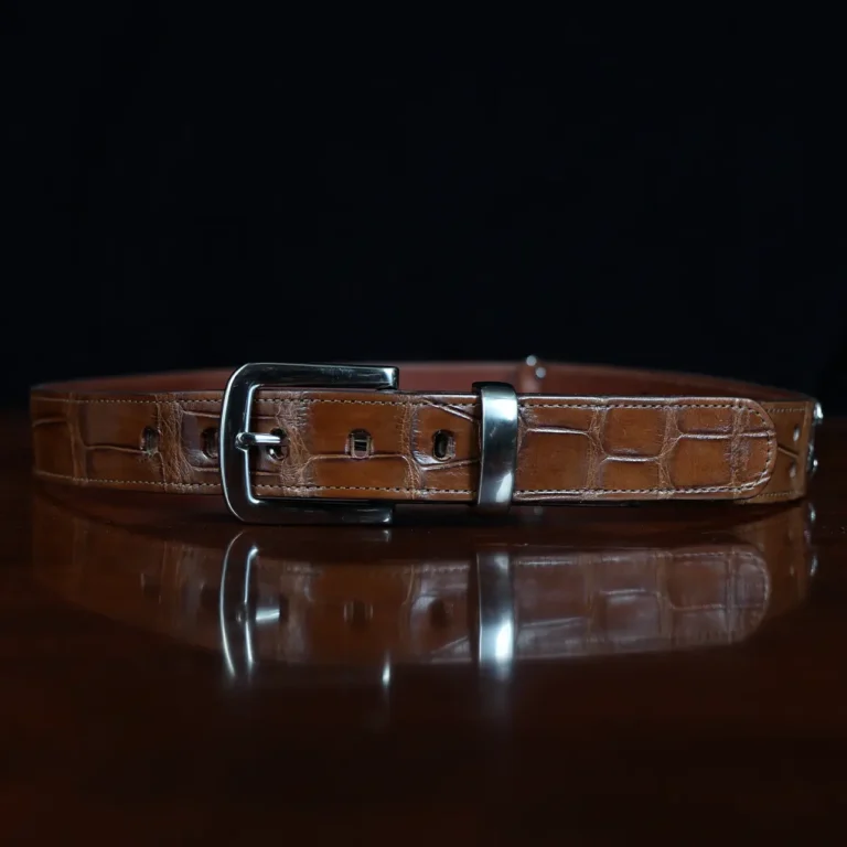 An American Alligator Belt with Nickel hardware showing the front view on a wooden table with black background - id 001