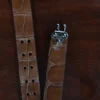 An American Alligator Belt with Nickel hardware showing the open hook view on a wooden table with black background - id 001