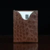 No. 4 Card Case in Vintage Brown American Alligator - ID 002 - front view with cardon a wood table and dark background