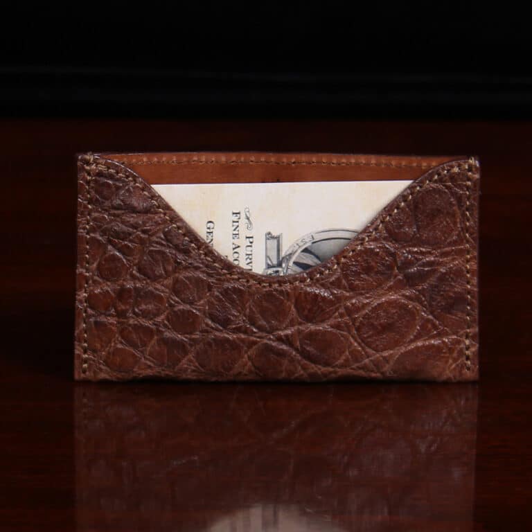 No. 3 Card Wallet in Vintage Brown American Alligator - ID 001 - front view cut out on No. 2 Card Wallet in Vintage Brown American Alligator - ID 001 - front view with business card on a black background