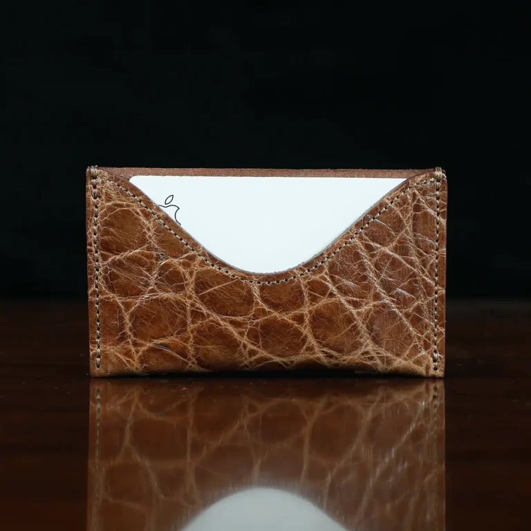 No. 3 Card Wallet in Vintage Brown American Alligator - ID 003 - front view with business card cut out on No. 2 Card Wallet in Vintage Brown American Alligator - ID 001 - front view with card on a black background