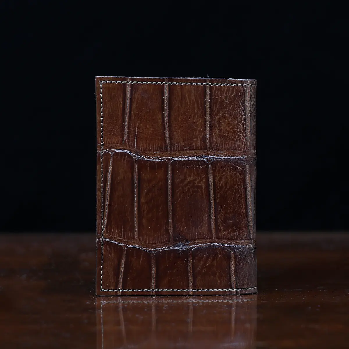 View larger image of No. 2 card wallet in Vintage Brown American Alligator - ID 001 - back view on a wood table and dark background