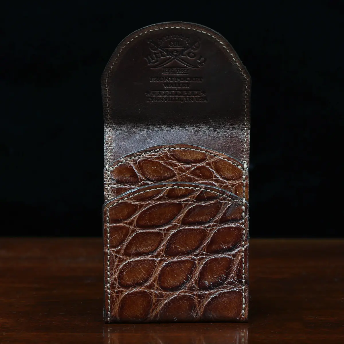 View larger image of Front pocket wallet with flap in brown American Alligator - front open view - 001 - on wood table with a dark background