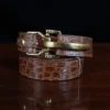 no 5 cinch belt in american alligator - size small- front coiled view on a wood table and dark background - id 002