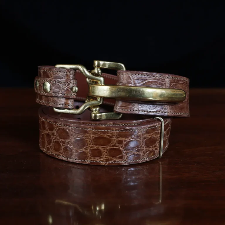 no 5 cinch belt in american alligator - size small- front coiled view on a wood table and dark background - id 002