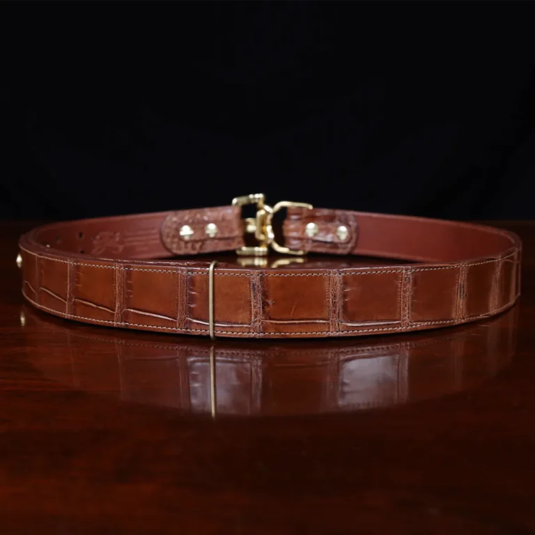 No. 5 Cinch Belt in brown American Alligator and brass buckle - ID 001 - back view on black background and wooden table