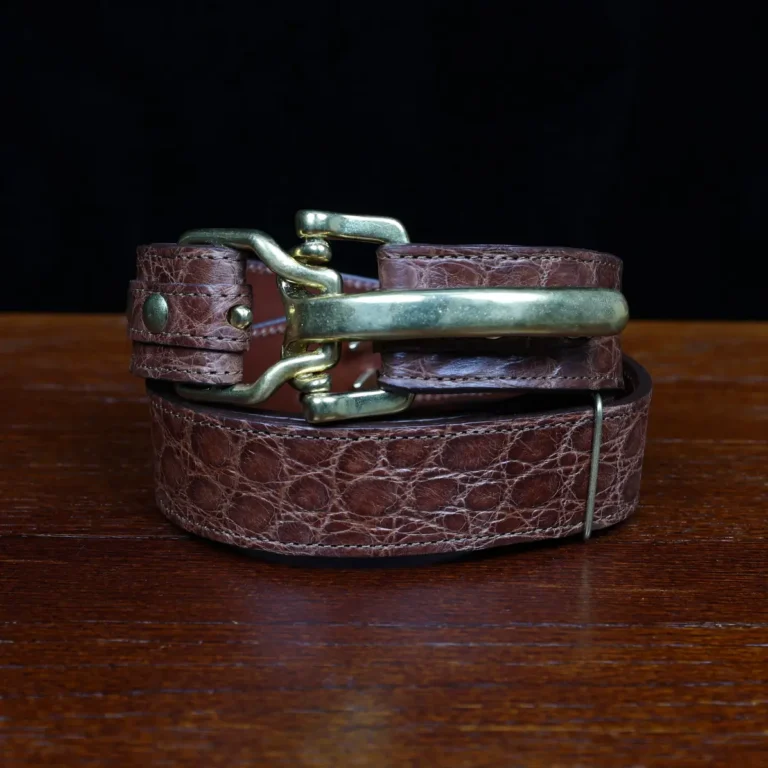 no 5 cinch belt in american alligator - size small- front coiled view on a wood table and dark background - id 002