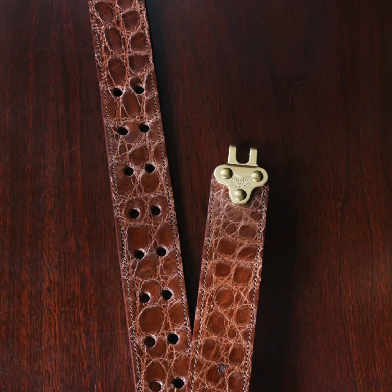 no 5 cinch belt in american alligator - size small- hook view on a wood table and dark background - id 002