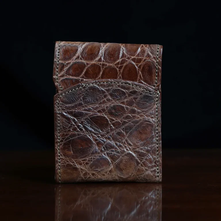 Front pocket wallet with flap in brown American Alligator - front view - 002 - on wood table with a dark background