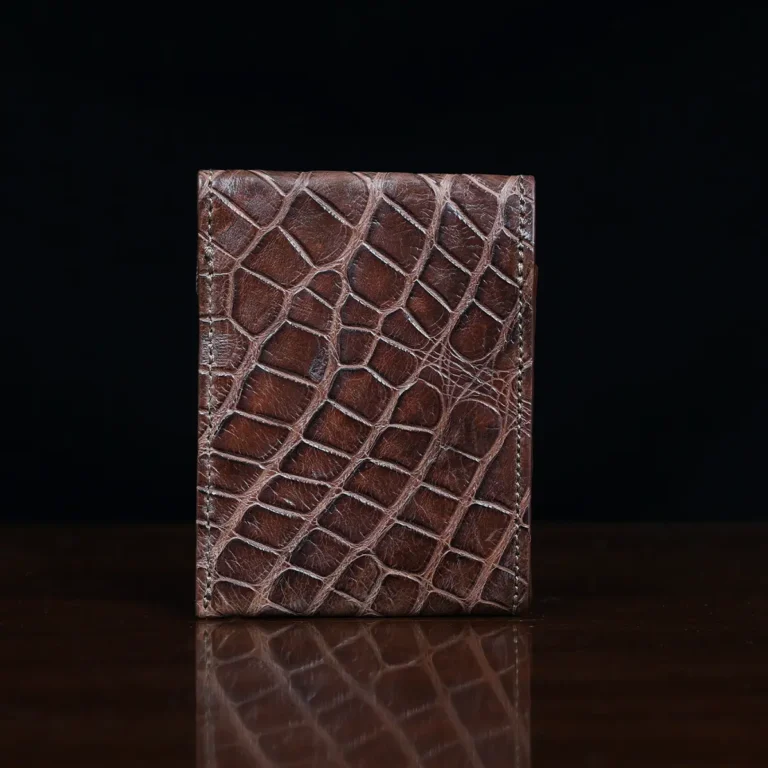 Front pocket wallet with flap in brown American Alligator - back view - 002 - on wood table with a dark background