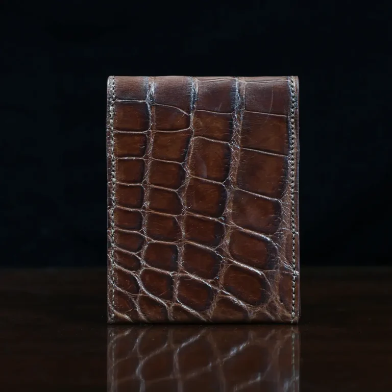 Front pocket wallet with flap in brown American Alligator - back view - 002 - on wood table with a dark background