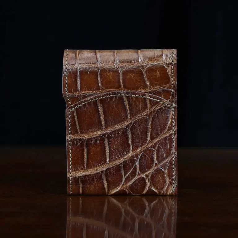 Front pocket wallet with flap in brown American Alligator - front view - 002 - on wood table with a dark background