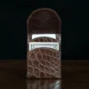Front pocket wallet with flap in brown American Alligator - front open view with money - 002 - on wood table with a dark background