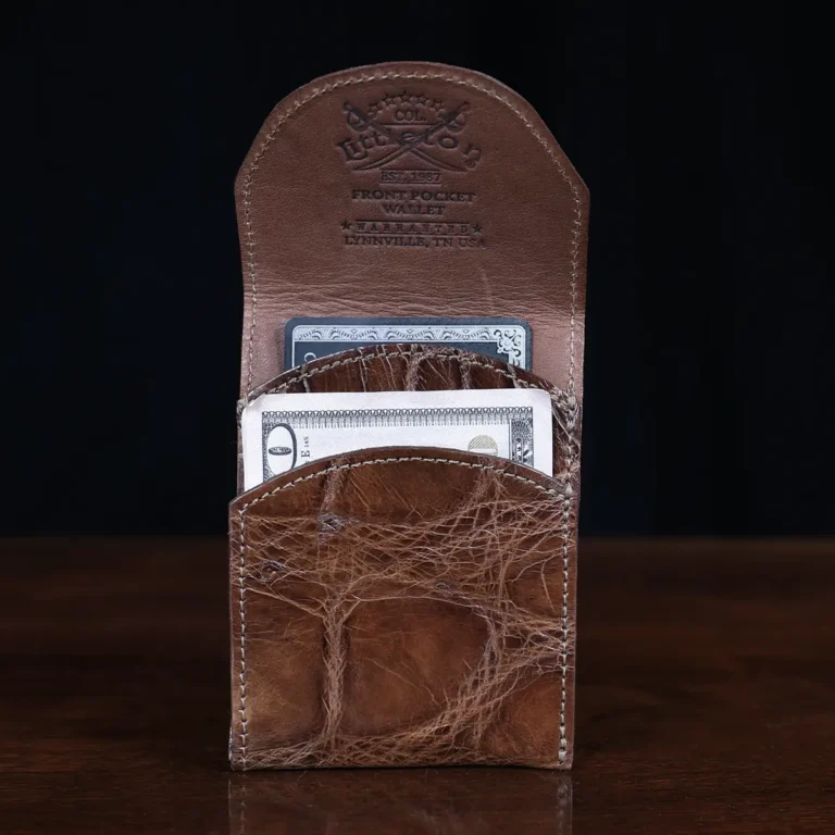 Front pocket wallet with flap in brown American Alligator - front view with money - 002 - on wood table with a dark background