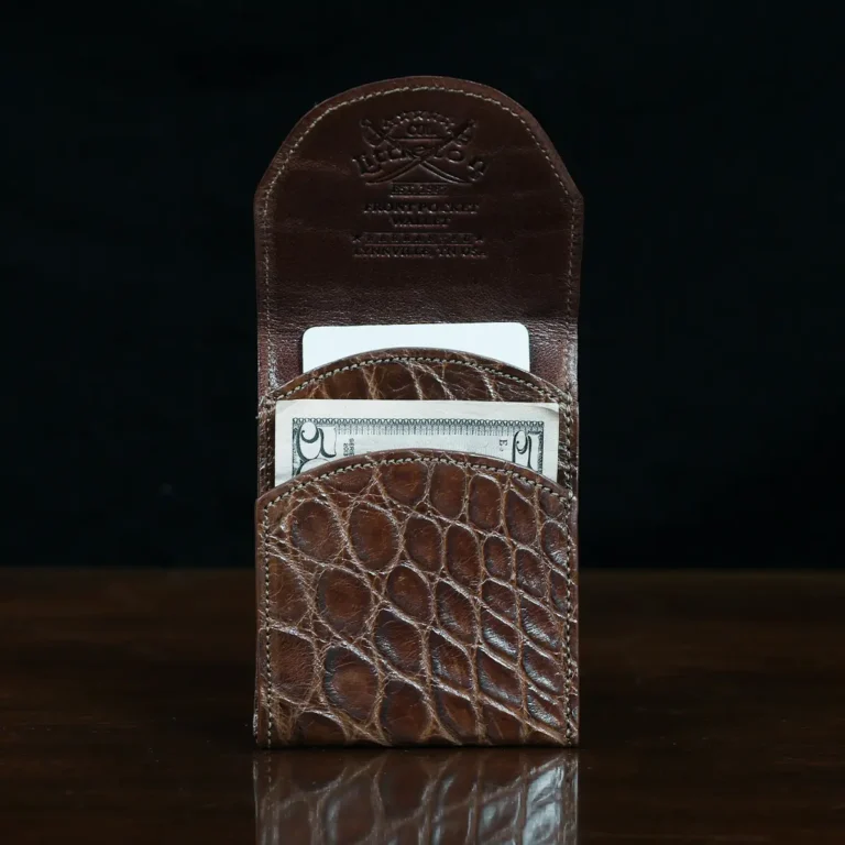 Front pocket wallet with flap in brown American Alligator - front view with money - 002 - on wood table with a dark background