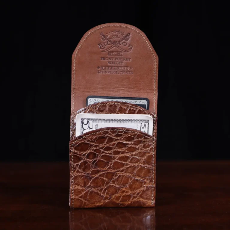 Front pocket wallet with flap in brown American Alligator - front open view with money - 002 - on wood table with a dark background