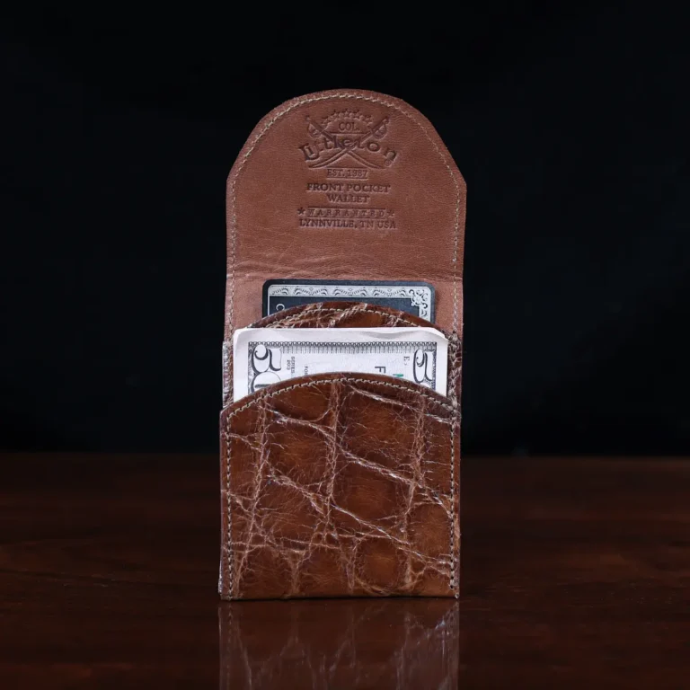 Front pocket wallet with flap in brown American Alligator - front open view with money - 002 - on wood table with a dark background