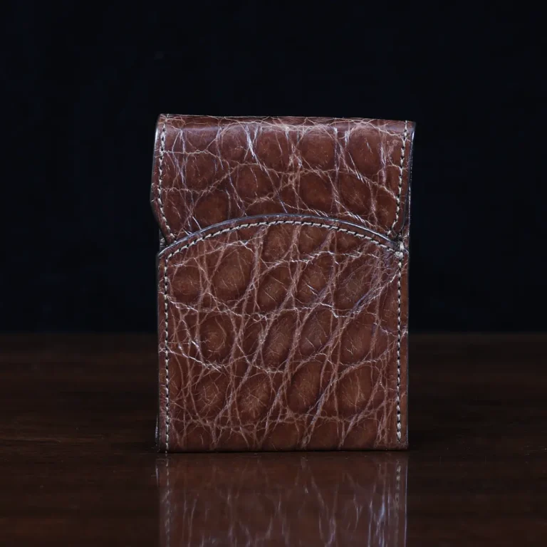Front pocket wallet with flap in brown American Alligator - front view - 002 - on wood table with a dark background
