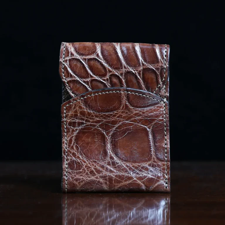 Front pocket wallet with flap in brown American Alligator - front view - 002 - on wood table with a dark background