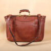 brown leather messenger book bag on table