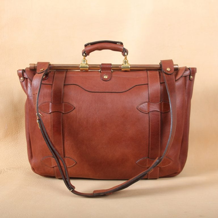 brown leather messenger book bag on table