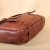 brown leather messenger book bag on table