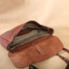 brown leather messenger book bag on table