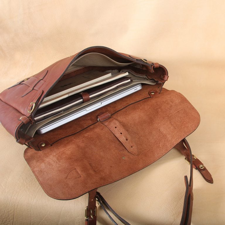 brown leather messenger book bag on table