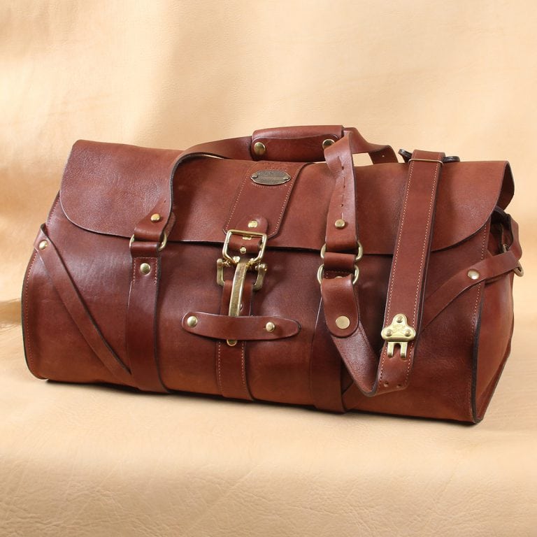 leather travel bag with adjustable shoulder strap brass prong adjustment.