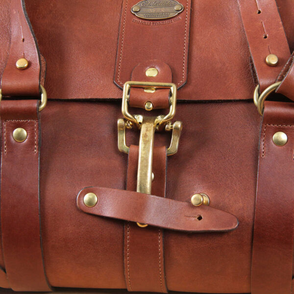 leather travel bag brass level style buckle in front.