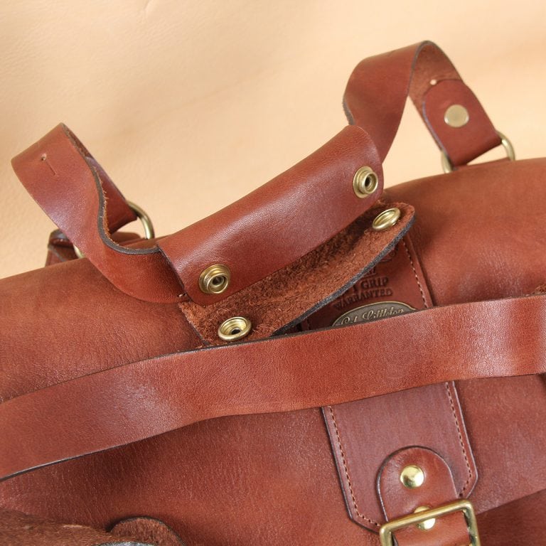 leather travel bag brown handles with two brass buckles.