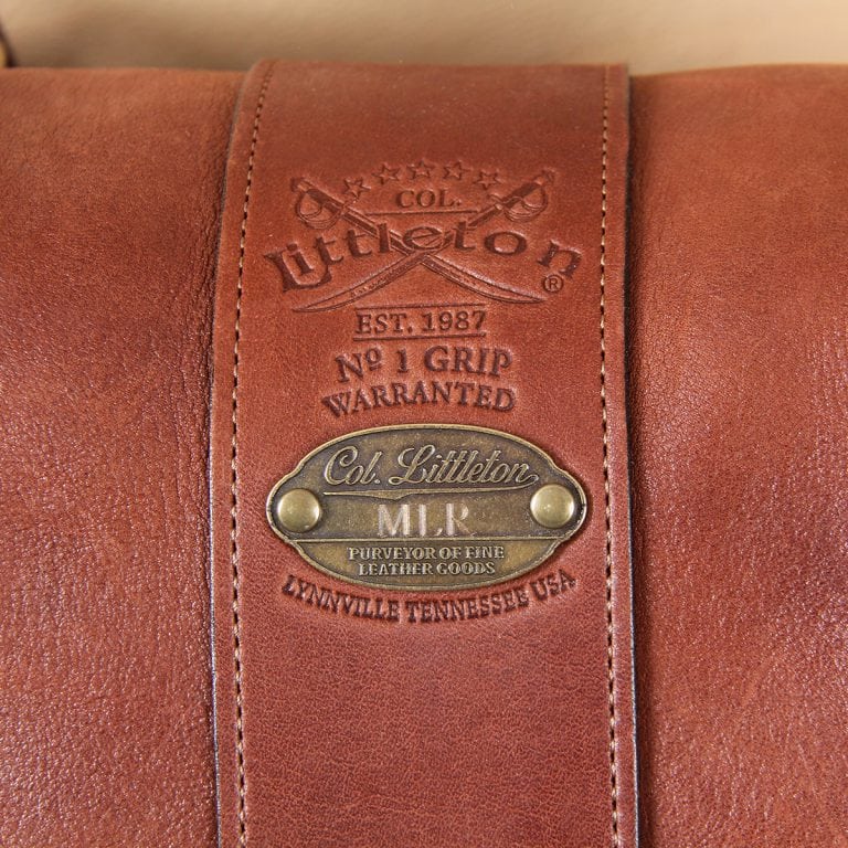 leather travel bag front embossed logo on brown leather with antique brass plate.