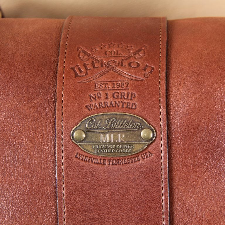 leather travel bag front embossed logo on brown leather with antique brass plate.