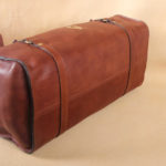 leather travel grip bag on table