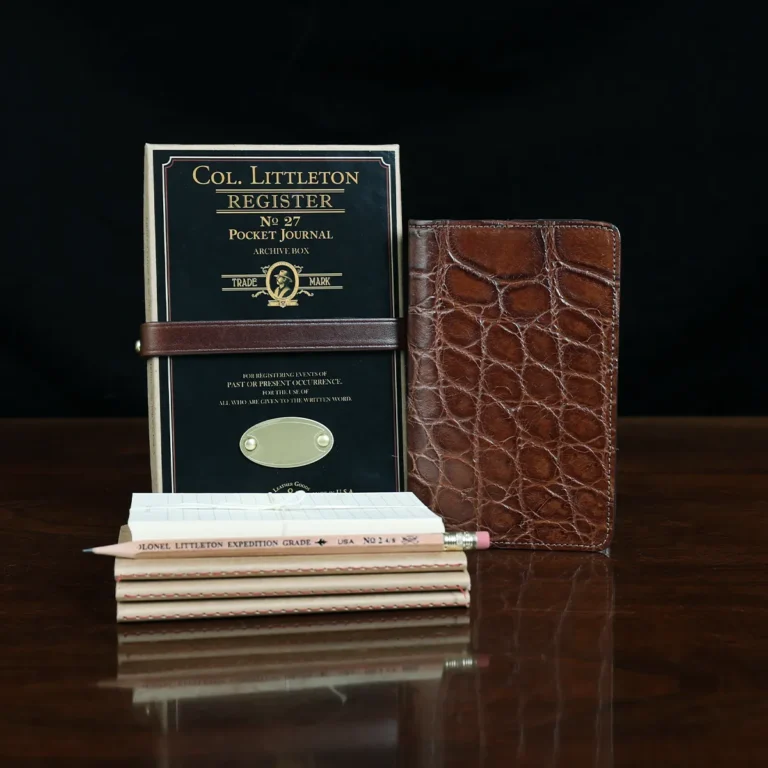 No. 27 Pocket Journal in American Alligator - ID 001 - front view, shown with journal register archive box, 3 journal register notebooks, a stack of cream index notecards, and a Col. Littleton wooden No. 2 pencil - on black background