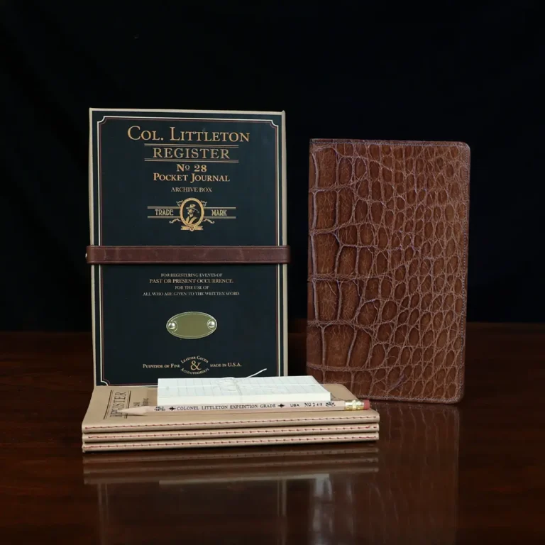 No. 28 Pocket Journal in Vintage Brown American Alligator - ID 002 - front view, shown with journal register archive box, 2 journal register notebooks, a stack of cream index notecards, and a Col. Littleton wooden No. 2 pencil - on black background