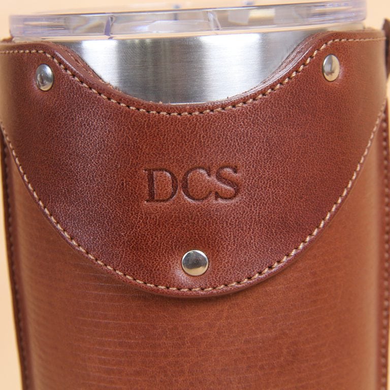 Leather tumbler sleeve for 20 ounce Yeti Rambler cup close up of 3 initials embossed on front of brown leather.