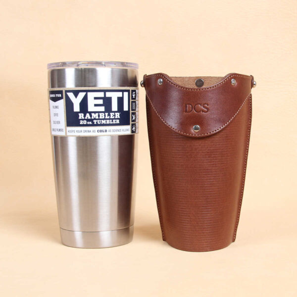 Leather tumbler sleeve for 20 ounce Yeti Rambler cup brown sleeve sitting with stainless steel cup side by side.