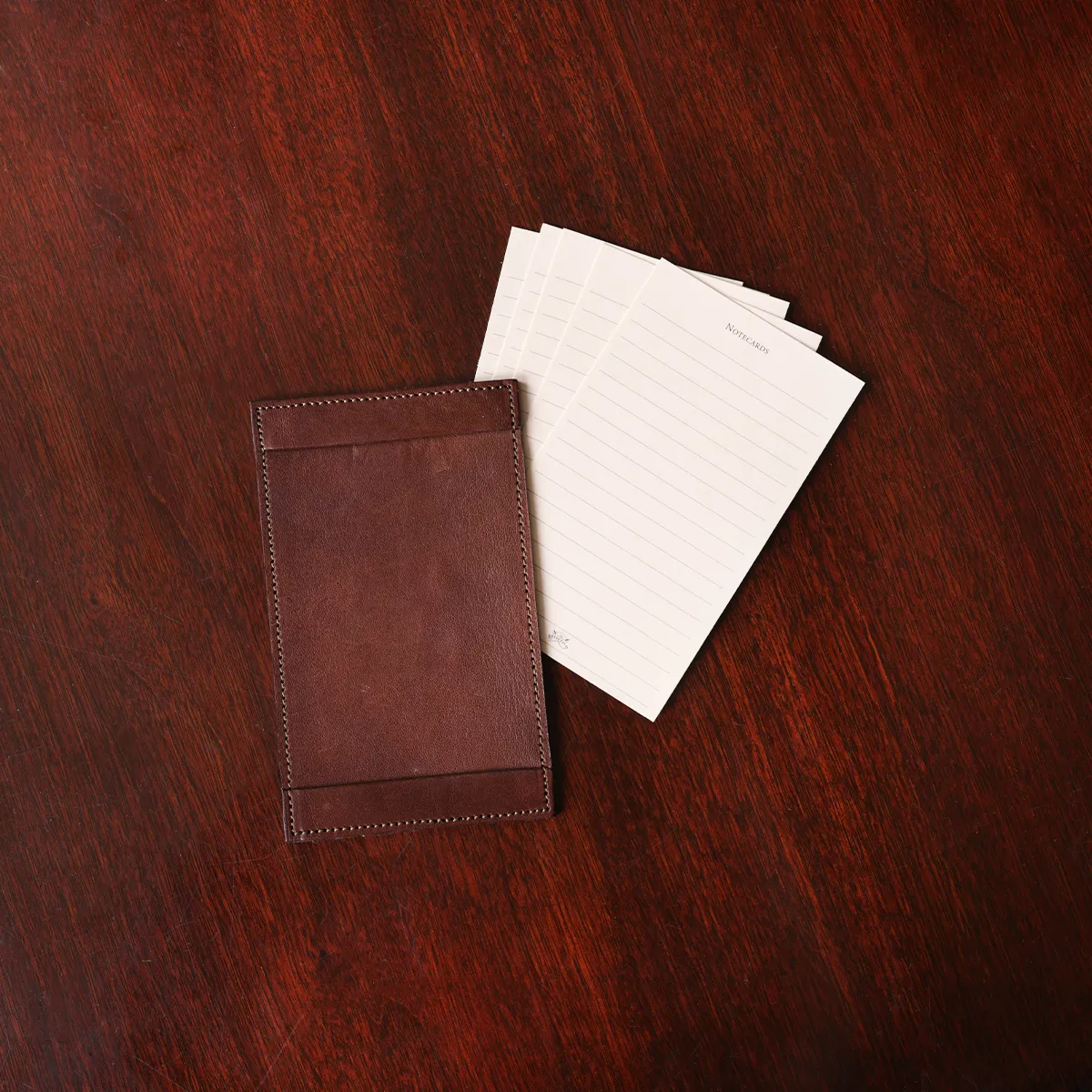 no1 vintage brown leather note card case with notes on a wooden table