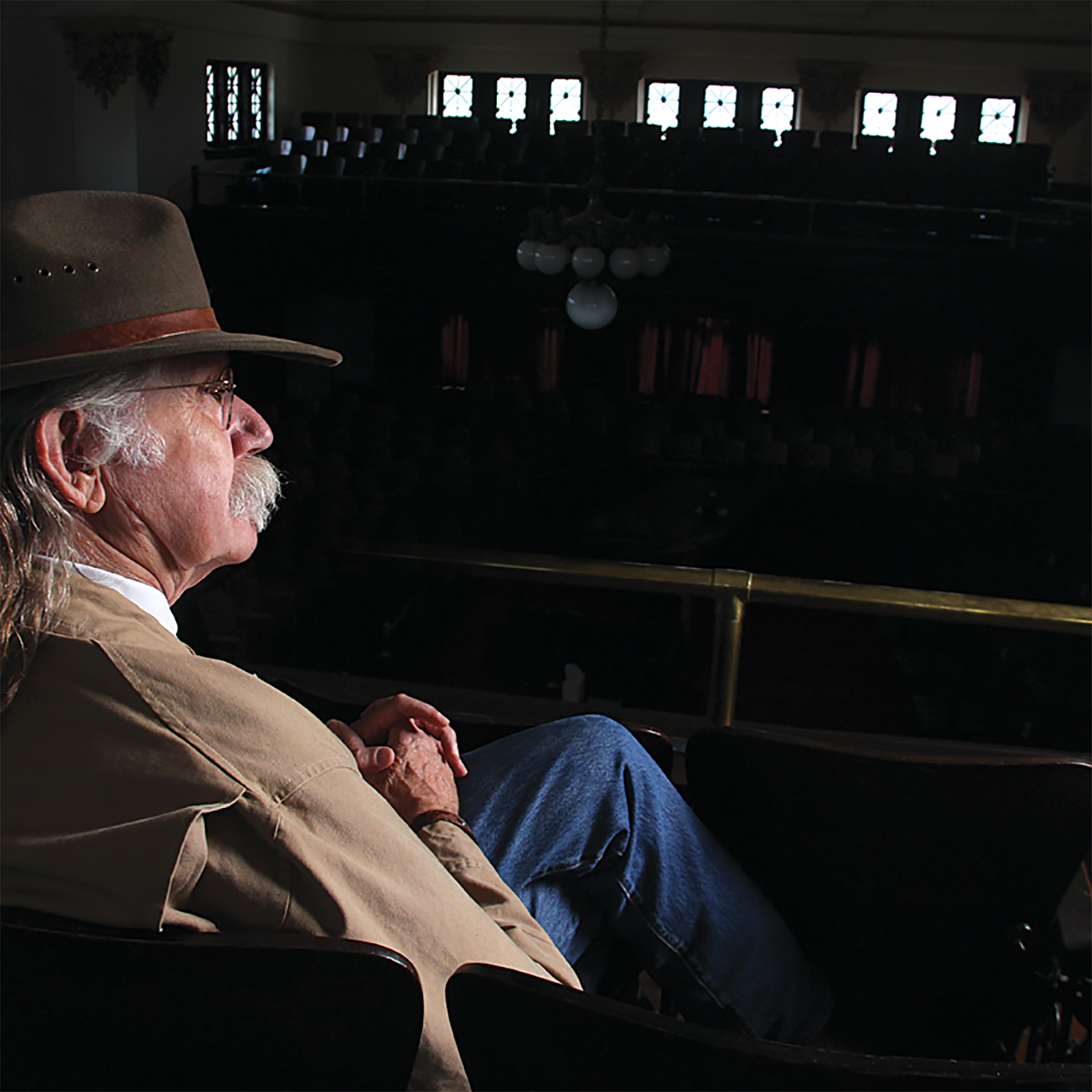 Colonel sitting in the upper balcony of a darkened courtroom in the Pulaski Courthouse