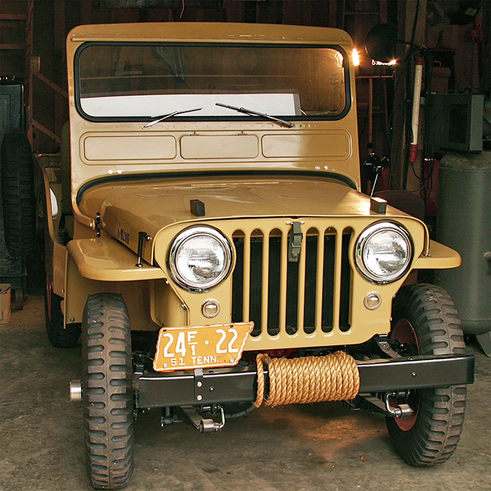 1951 restored Willy's Jeep, khaki-colored, with an orange and while Tennessee-shaped license plate on the front