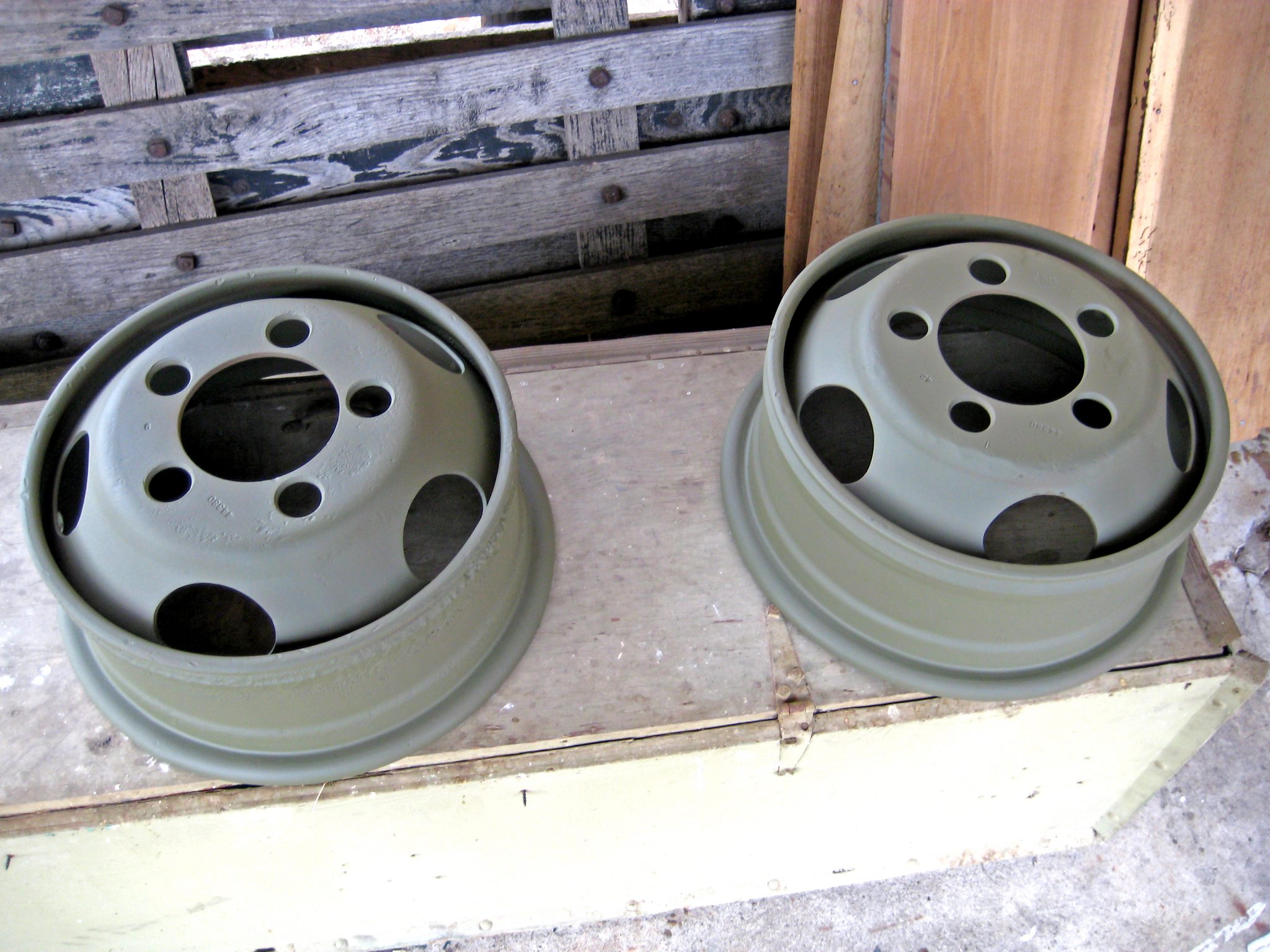 Newly painted army green metal tire hubs for a 1941 Army Command Car.