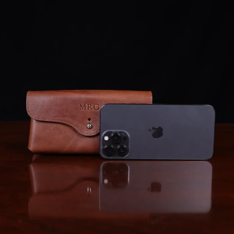 front view of the phone holster in vintage brown american steerhide with a phone in front for size reference