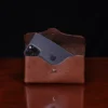 no 48xl leather phone holster with phone on a wooden table and dark background - front open view