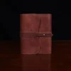 no9 brown american leather journal with notepad on wood table with dark background