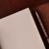 no9 brown american leather journal with notepad unruled paper on wood table with dark background
