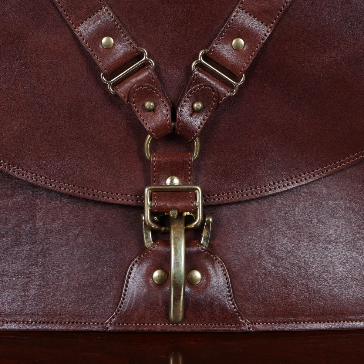 commander leather laptop briefcase on a wooden table with a dark background - front view of cinch