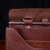 commander leather laptop briefcase on a wooden table with a dark background - open view of copper rod